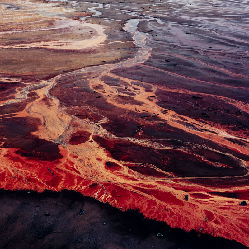 Famous Canadian landscape photographer Edward Burtynsky captures nickel tailings in Sudbury, Ontario in 1996. This photograph depicts a menacing body of molten-orange liquid that sprawls and meanders through a dreary and barren landscape.