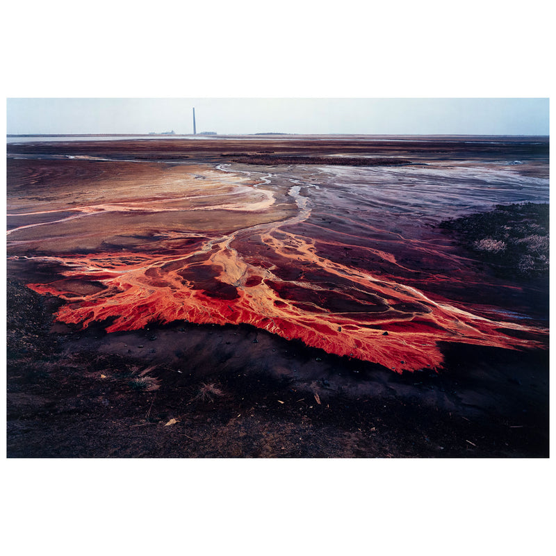 Famous Canadian landscape photographer Edward Burtynsky captures nickel tailings in Sudbury, Ontario in 1996. This photograph depicts a menacing body of molten-orange liquid that sprawls and meanders through a dreary and barren landscape.