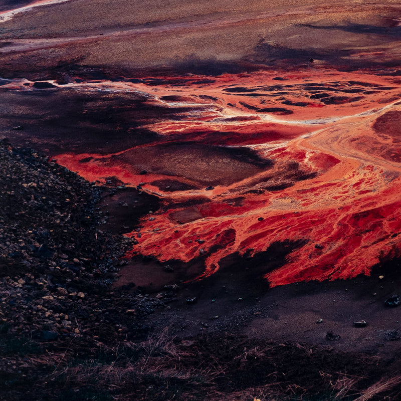 Famous Canadian landscape photographer Edward Burtynsky captures nickel tailings in Sudbury, Ontario in 1996. This photograph depicts a menacing body of molten-orange liquid that sprawls and meanders through a dreary and barren landscape.