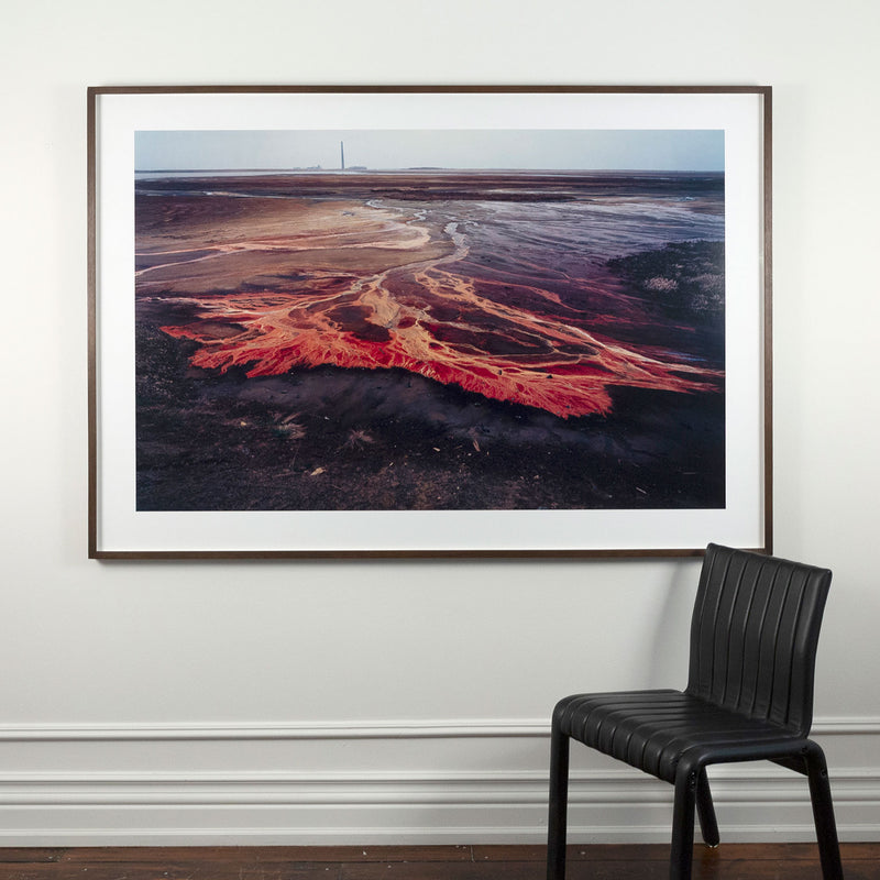 Famous Canadian landscape photographer Edward Burtynsky captures nickel tailings in Sudbury, Ontario in 1996. This photograph depicts a menacing body of molten-orange liquid that sprawls and meanders through a dreary and barren landscape.