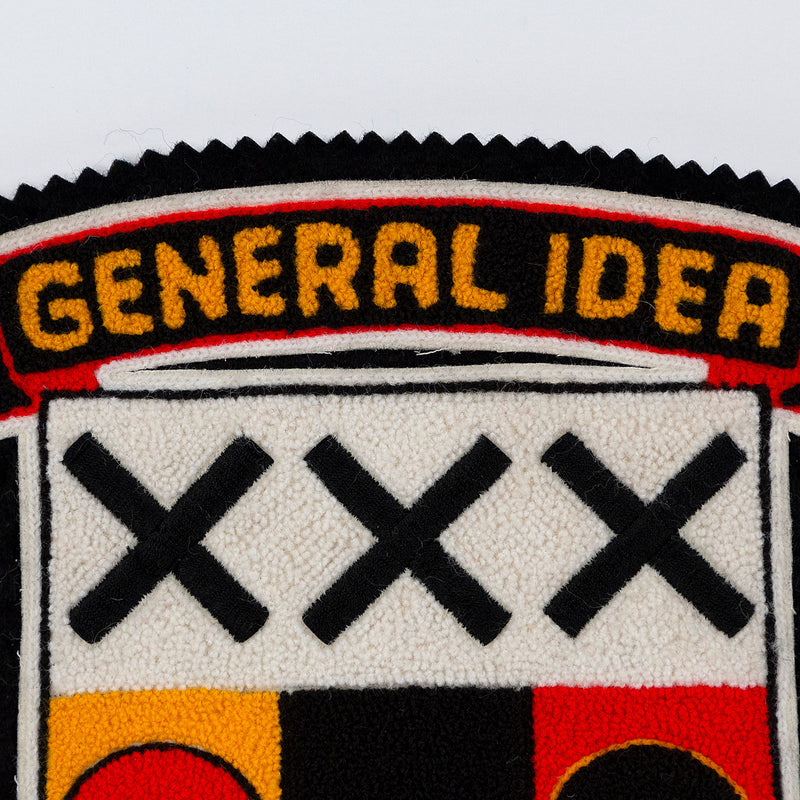 General Idea "Post Mortem" Chenille crest, 1988. Textile patch featurings a trio of skulls and alternating shades of yellow, red, and black.