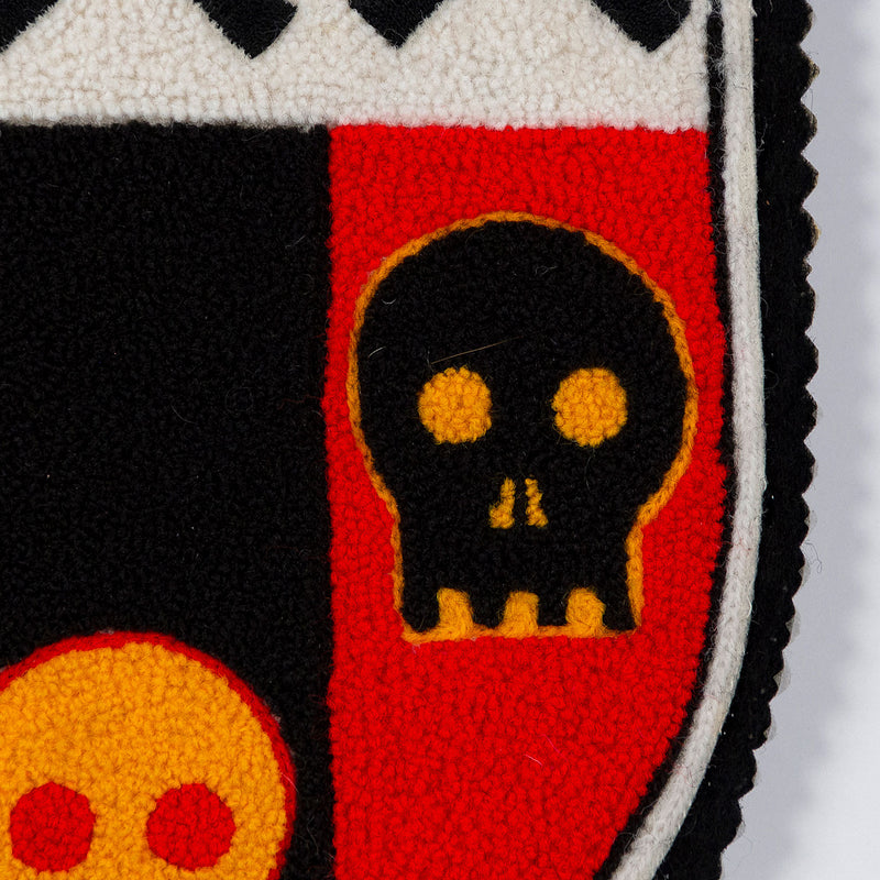 General Idea "Post Mortem" Chenille crest, 1988. Textile patch featurings a trio of skulls and alternating shades of yellow, red, and black.