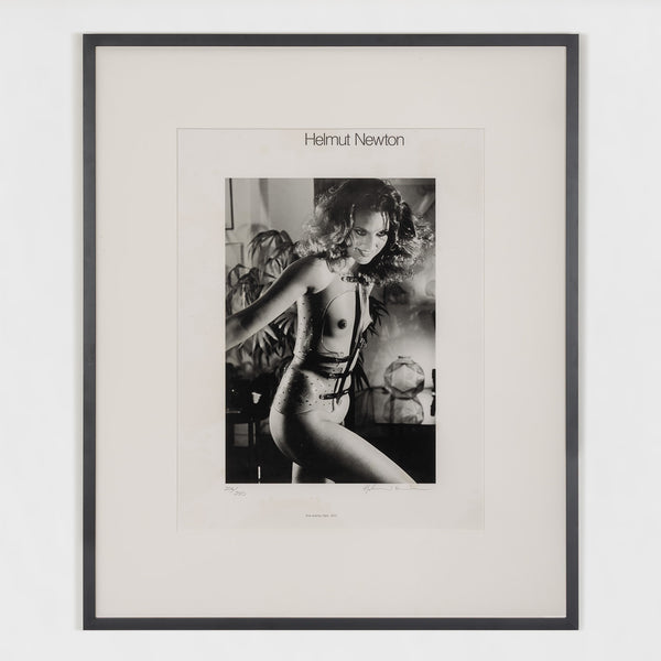 Framed black and white photograph by Helmut Newton featuring a model in a provocative pose.