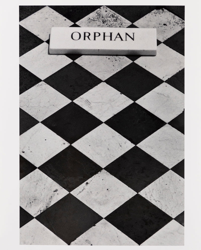 Sophie Callie "Orphan" Gelatin silver print, 1994. "Orphan" is a poignant example of the artist's inquiry into death, loss, and departure. The photograph features a close crop of a black and white checkered tombstone with an inscription plaque that reads, 'Orphan.'     
