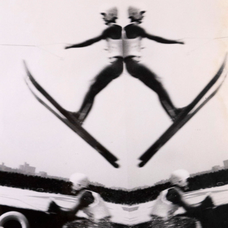 Weegee. Untitled "Waterski Jumper" USA, 1950. Gelatin silver print. Toronto gallery. The dynamic image features two waterskiers, one suspended in the air mid-jump, while the other touches down, prompting a spray of water upon impact. This brief moment of daring motion is distorted into an almost perfectly symmetrical image, with limbs and perspective lines converging at the center for an almost Op Art effect.