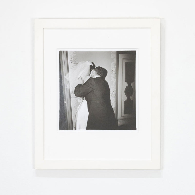 Diane Arbus "Groom Kissing his Bride" Gelatin silver print, 1966. Love and tension confront each other as the groom kisses the bride with an attacking passion. Her likeness disappears behind his embrace and their newlywed bodies merge together. This work also contains Arbus’ visual trademarks – a black and white palette, a square crop, and a hard flash that flattens the aesthetic wonderland of New York.