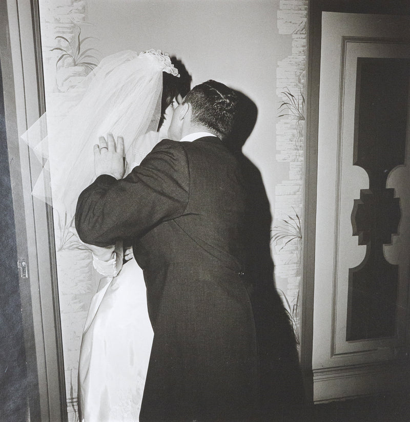 Diane Arbus "Groom Kissing his Bride" Gelatin silver print, 1966. Love and tension confront each other as the groom kisses the bride with an attacking passion. Her likeness disappears behind his embrace and their newlywed bodies merge together. This work also contains Arbus’ visual trademarks – a black and white palette, a square crop, and a hard flash that flattens the aesthetic wonderland of New York.