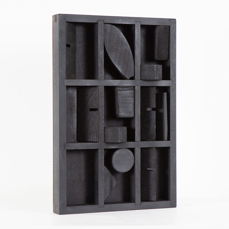 Louise Nevelson "Winter Chord" Mixed media sculpture, 1975. Wood sculpture painted black with unique recesses and curvatures that expose geometric shapes within the form. 