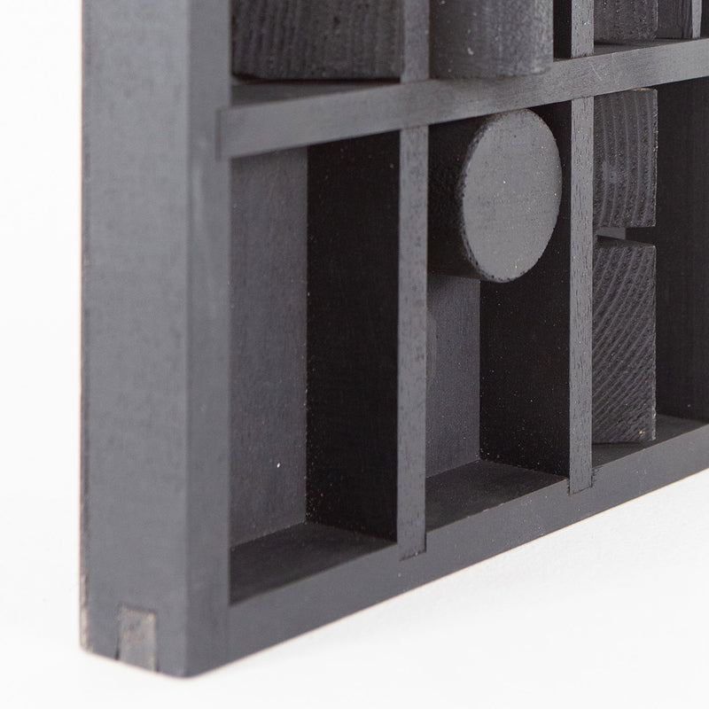 Louise Nevelson "Winter Chord" Mixed media sculpture, 1975. Wood sculpture painted black with unique recesses and curvatures that expose geometric shapes within the form. 