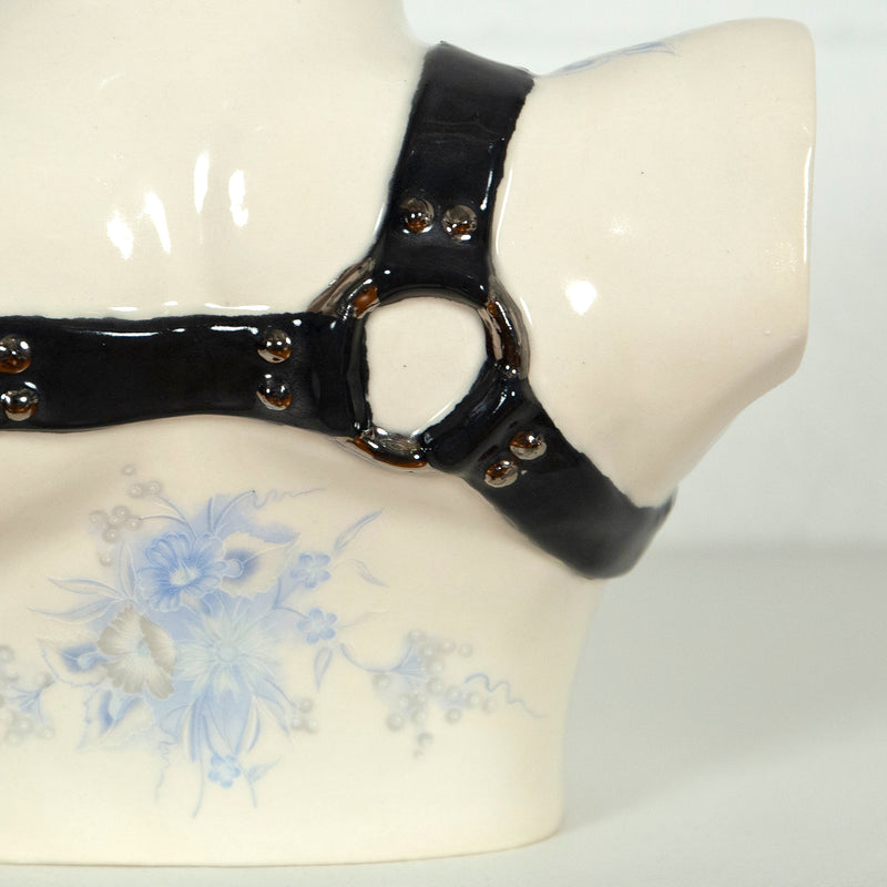 This is a ceramic vase for sale from Caviar20. Made by Pansy Ass and represents a torso with a leather harness.